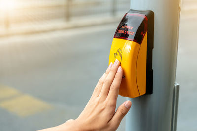 Close-up of hand over yellow button