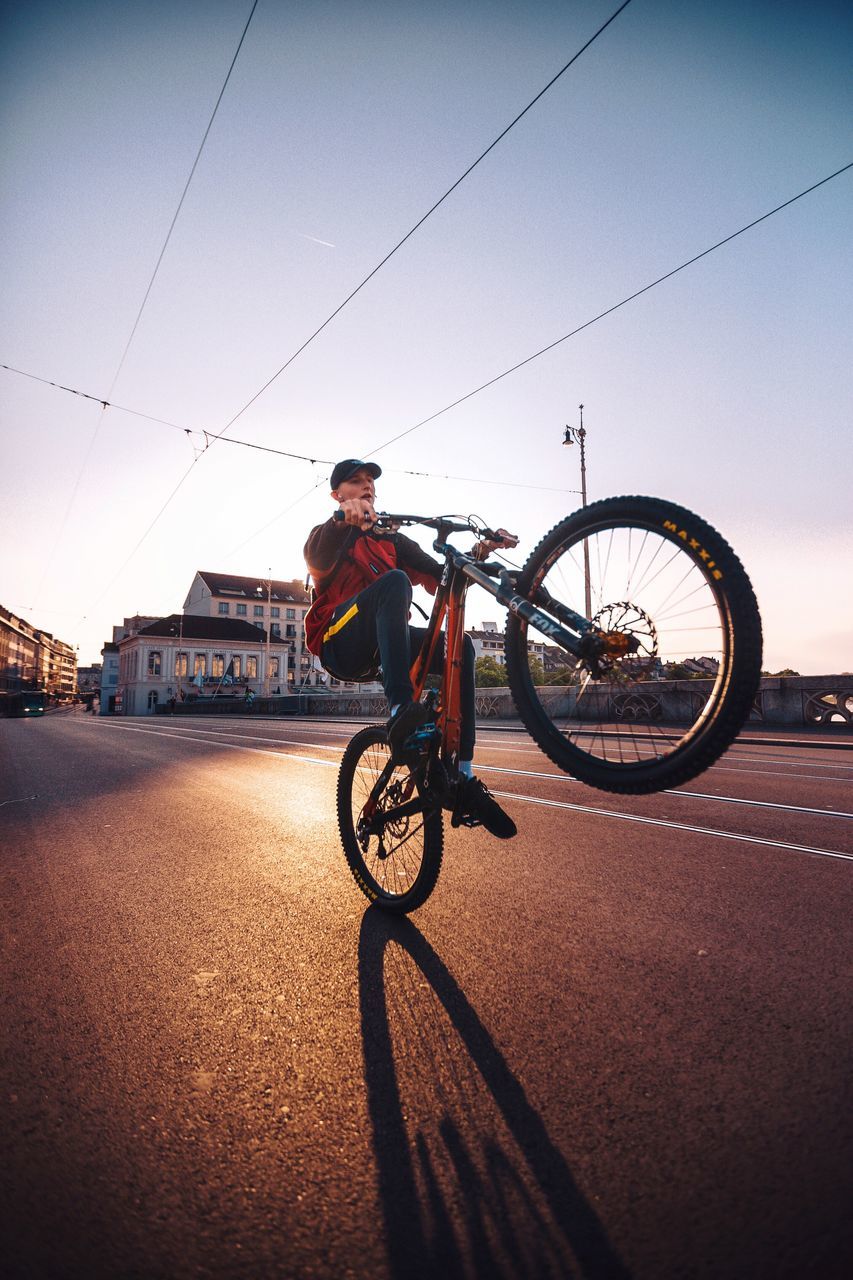 transportation, bicycle, land vehicle, sky, full length, mode of transportation, architecture, one person, real people, city, leisure activity, built structure, lifestyles, sport, ride, riding, cycling, activity, building exterior, nature, outdoors