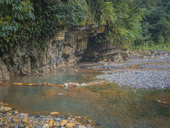 View of stream flowing through rocks