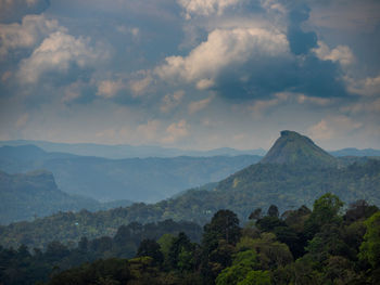 Scenic view of mountain range against cloudy sky