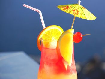 Close-up of drink in glass against blue sky