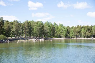 Scenic view of lake by trees against sky