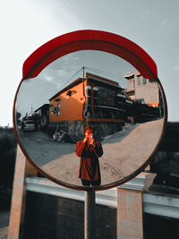 Rear view of man on red car against sky