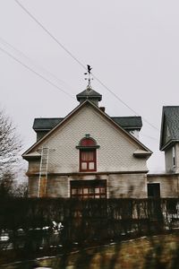 House by lake against sky