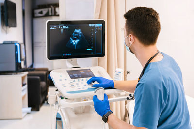 Doctor operating ultrasound machine at hospital