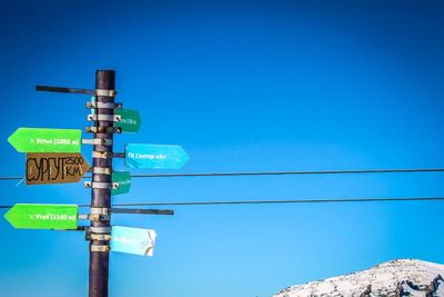 Close-up of road sign against clear blue sky