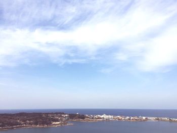 Scenic view of sea by city against sky