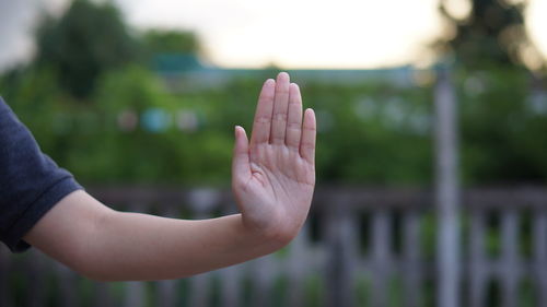 Close-up of females hand showing stop sign