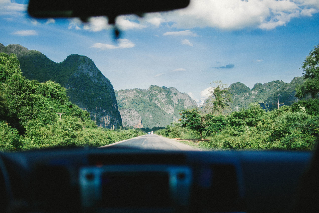 SCENIC VIEW OF TREES AND MOUNTAINS AGAINST SKY