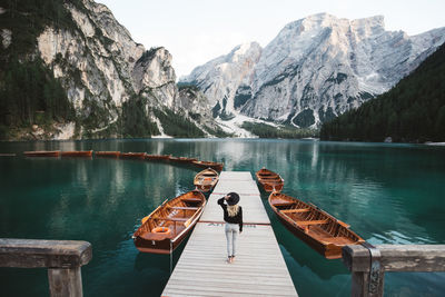 Rear view of woman walking on pier over lake