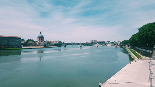 Bridge over river against cloudy sky