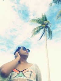 Low angle view of woman wearing sunglasses against sky