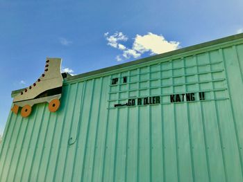 Low angle view of text on building against sky