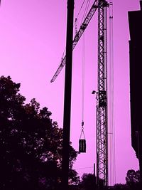 Low angle view of silhouette cranes against sky during sunset