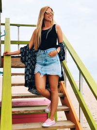 Low angle view of smiling woman standing on staircase