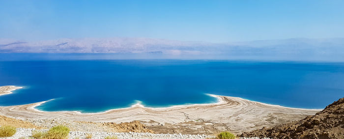 Panoramic view of sea and mountains against blue sky