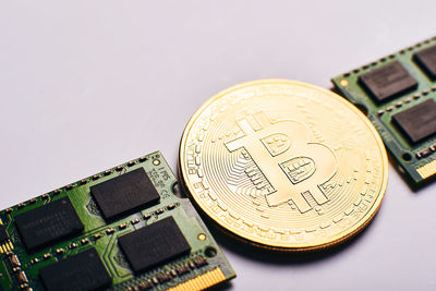 Close-up of bitcoin with computer equipment over white background