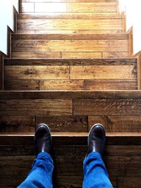 Low section of man standing on wooden floor