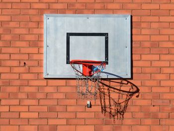 Low angle view of basketball hoop against brick wall