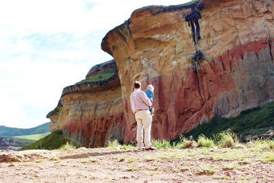 Rear view of man standing on rock