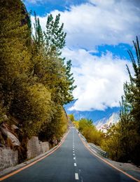 Road amidst trees against sky