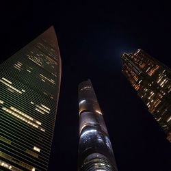 Low angle view of illuminated buildings against sky at night