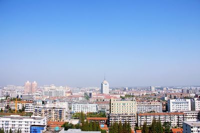 High angle view of cityscape against clear blue sky