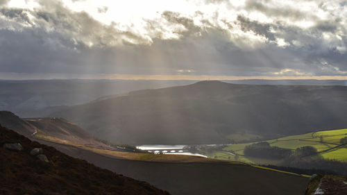 Scenic view of land and mountains against sky