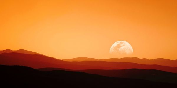 Scenic view of silhouette mountains against sky during sunset