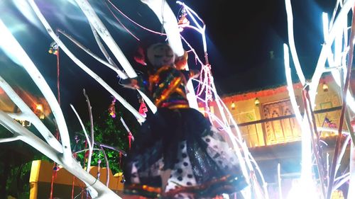 Low angle view of amusement park ride at night
