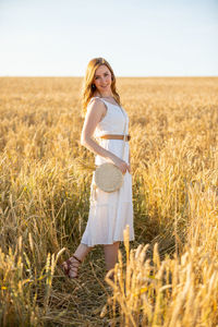 Portrait of smiling woman standing in field