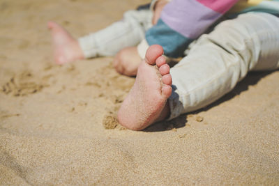 Low section of woman on sand at beach