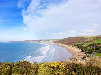 Scenic view of beach against cloudy sky