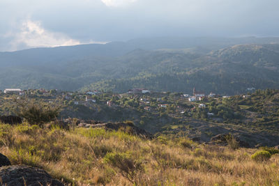 Scenic view of field and mountains against sky