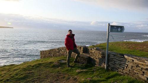 Man standing by sea against sky