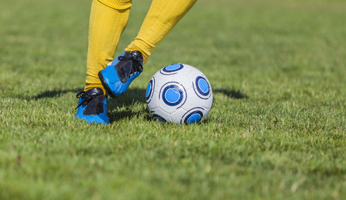 Low section of person playing soccer on field