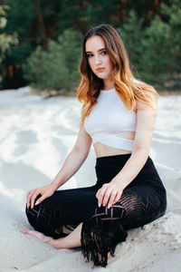 Woman sitting on a sandy beach