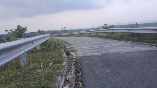 Empty road on field against sky