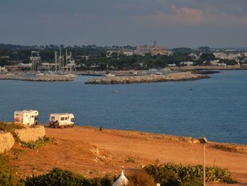 High angle view of townscape by sea against sky