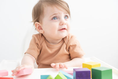 Portrait of cute girl with toy against white background