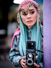 Beautiful asian female posing with a retro camera