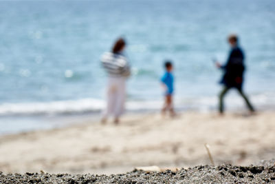 Defocused image of family on shore at beach