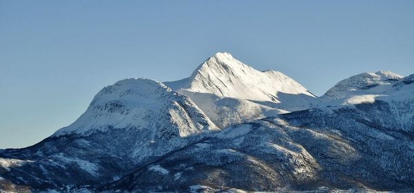 Scenic view of snowcapped mountains against clear blue sky