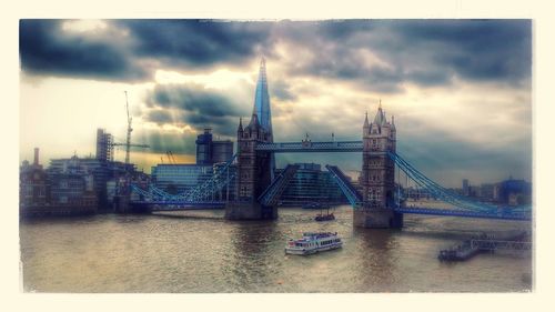 Bridge over river against cloudy sky