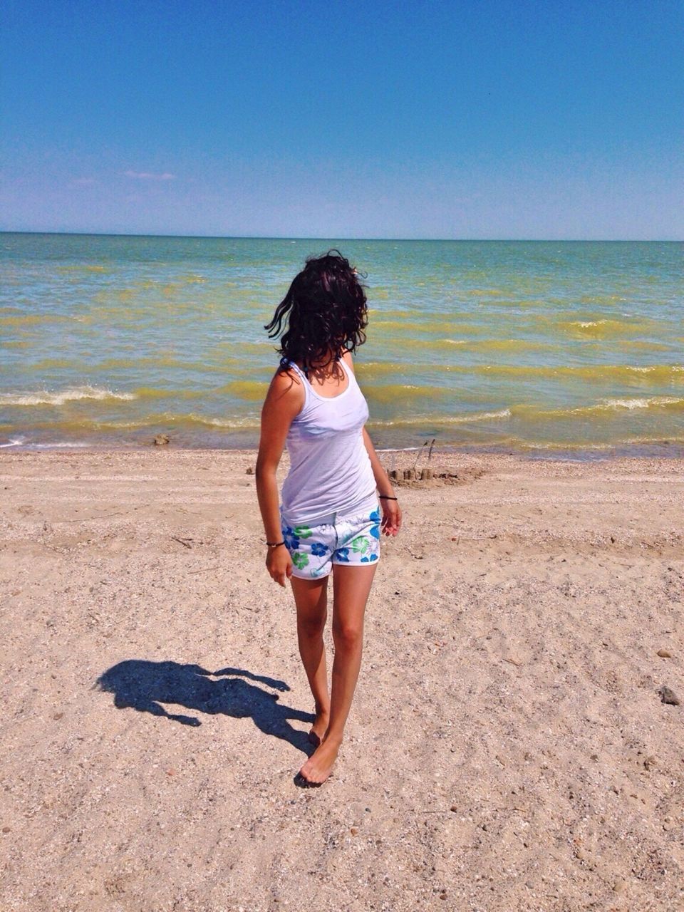 beach, sea, horizon over water, rear view, full length, water, shore, sand, tranquility, clear sky, lifestyles, leisure activity, standing, casual clothing, tranquil scene, beauty in nature, blue, scenics