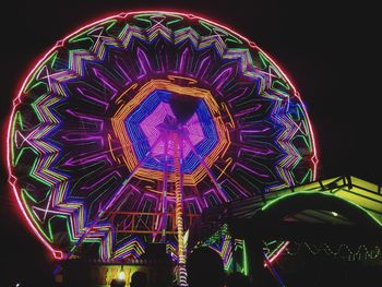 Low angle view of illuminated ferris wheel against sky at night