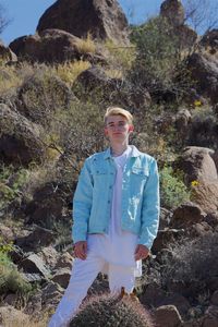 Portrait of young man standing on rock