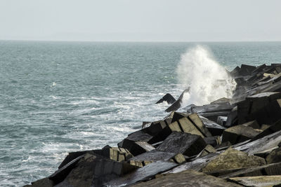 Scenic view of rocks in sea against clear sky