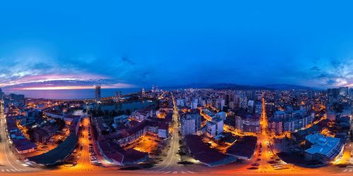 Illuminated cityscape against sky at dusk