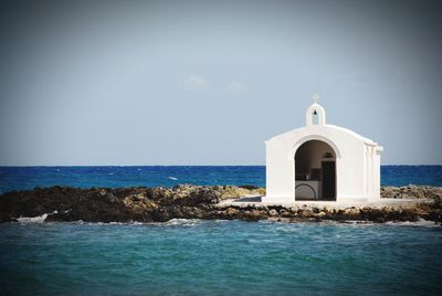 View of church by sea against sky